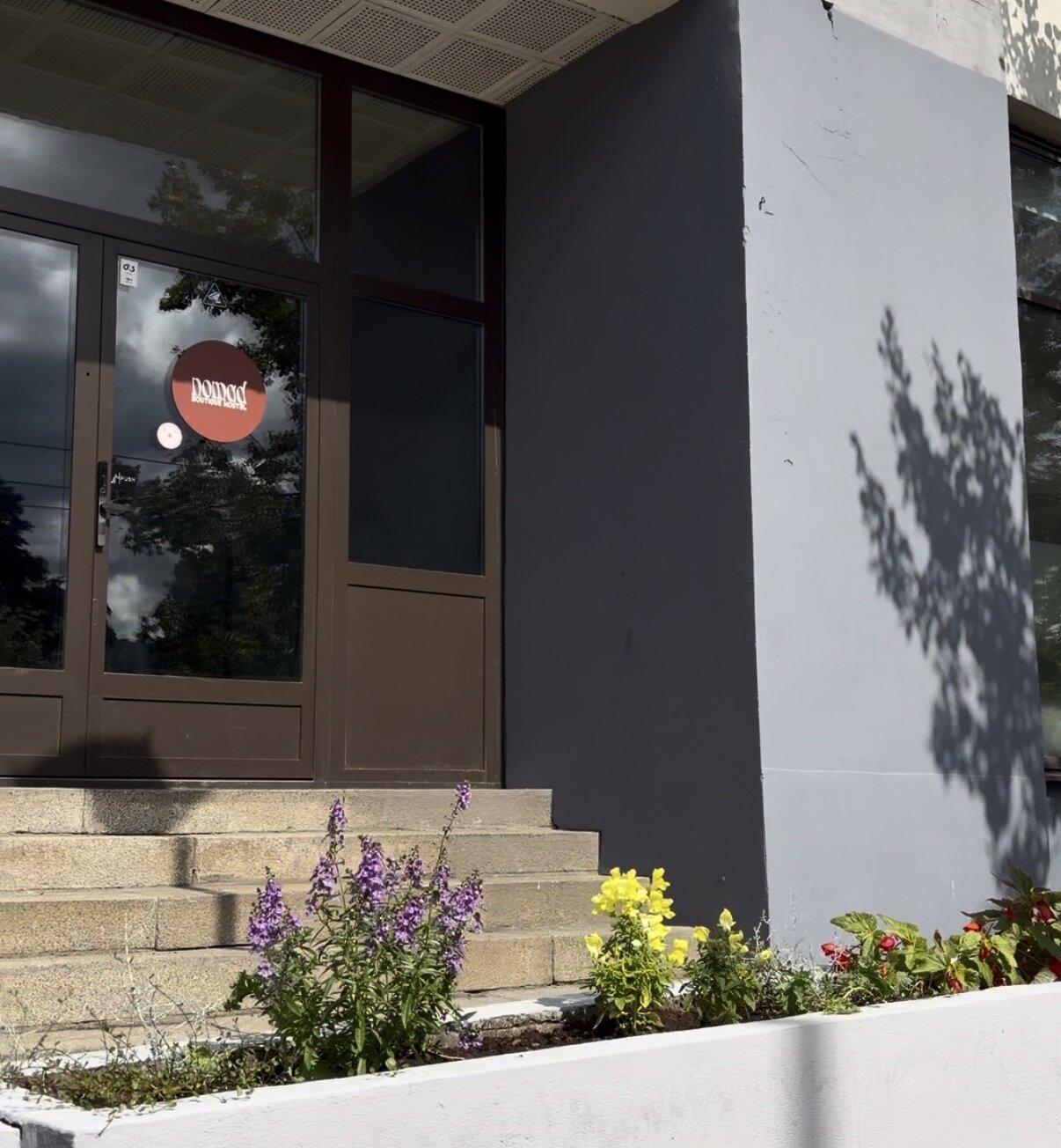 Entrance with the round nomad sign on the glass door